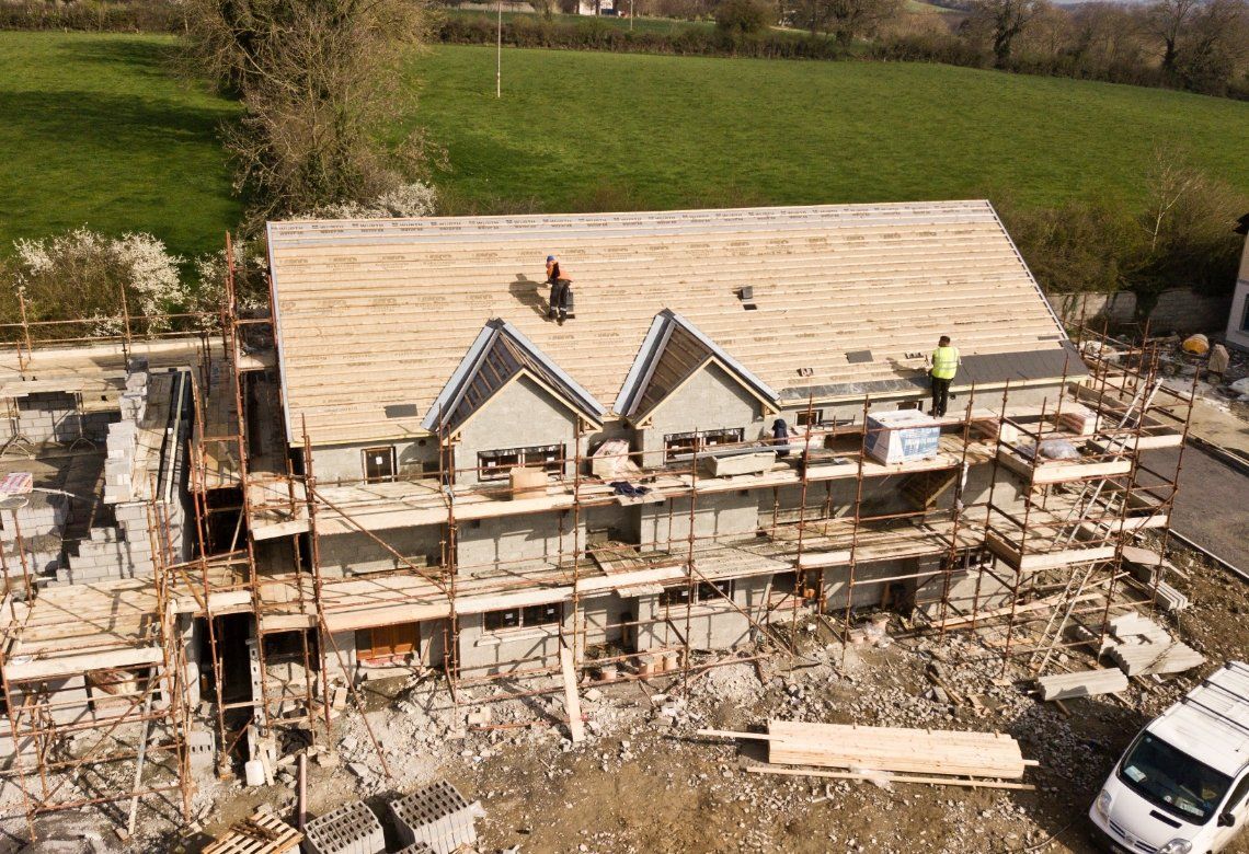 An aerial view of a house under construction with a van parked in front of it.