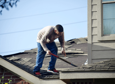 A man is working on the roof of a house.