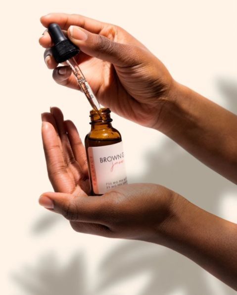 Een persoon houdt een flesje met een druppelaar in zijn hand