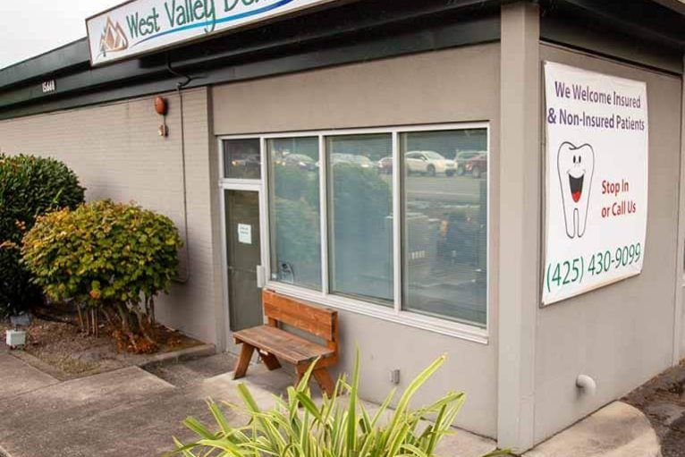 A dental office with a wooden bench in front of it.