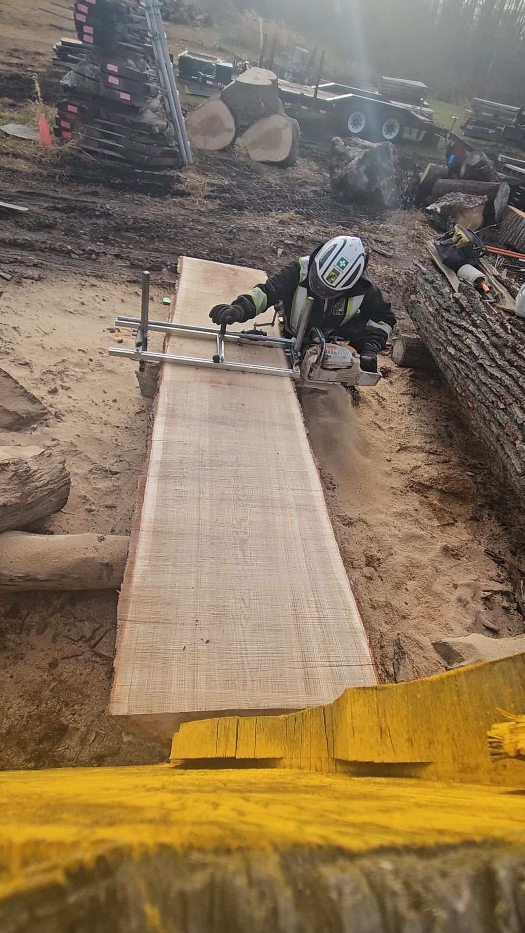 Un homme coupe un morceau de bois avec une scie.