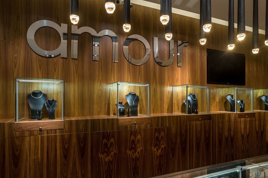 A jewelry store with a wooden wall and displays of jewelry.