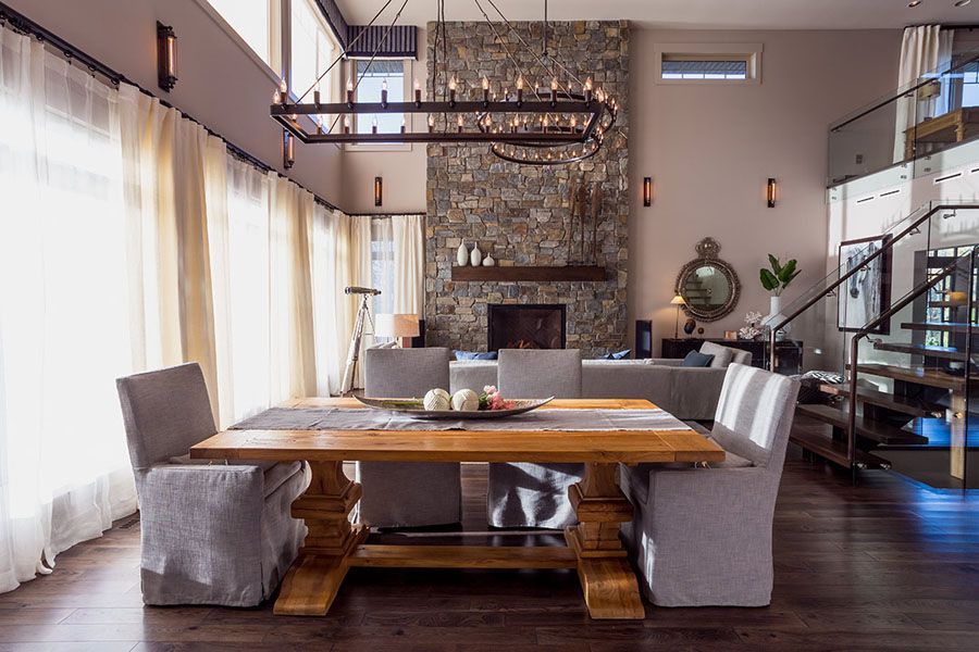 A dining room with a wooden table and chairs and a fireplace.