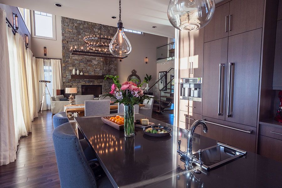 There is a vase of flowers on the counter in the kitchen.