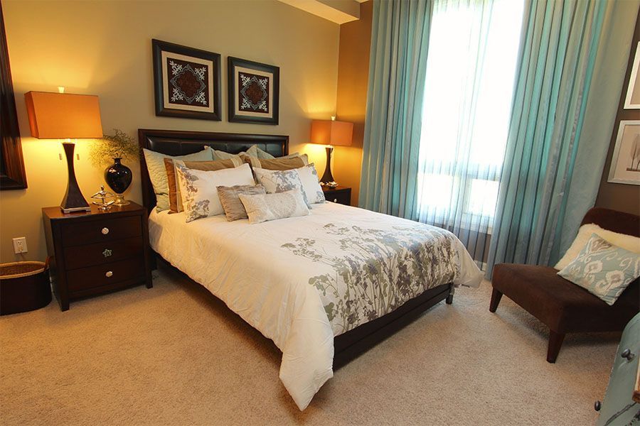 A bedroom with a large bed and a chair