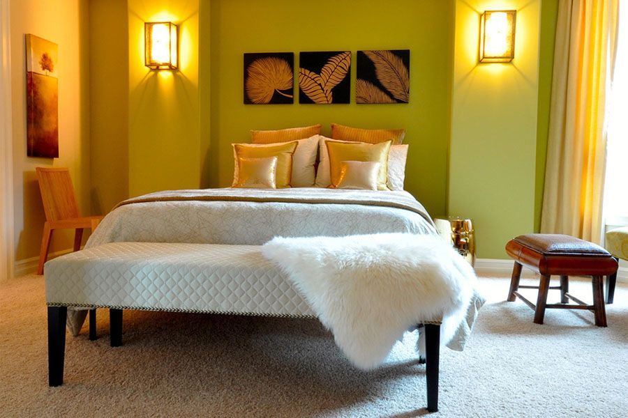 A bedroom with green walls and a white bed