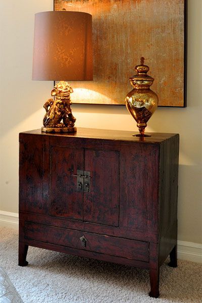 A lamp is sitting on top of a wooden cabinet