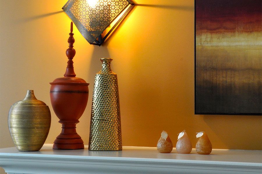 A mantle with a lamp and vases on it