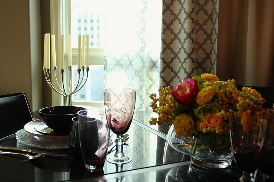 A dining room table with a vase of flowers on it