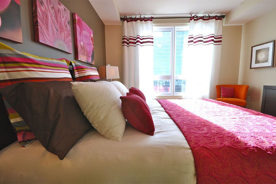 A bedroom with a king size bed and a chair