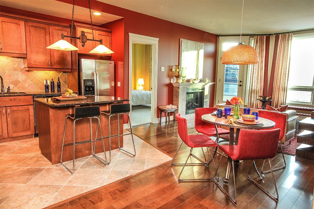 A kitchen and dining room with red chairs and tables