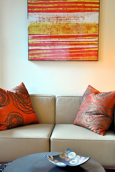 A living room with a couch and a painting on the wall