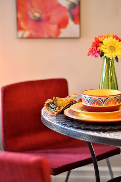 A table with plates and bowls and a vase of flowers on it