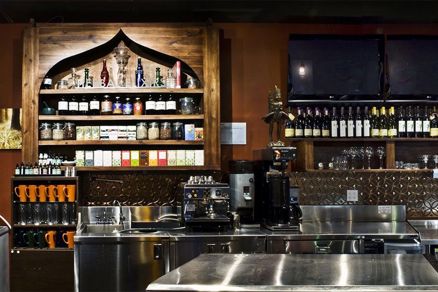 A kitchen with stainless steel appliances and bottles on shelves