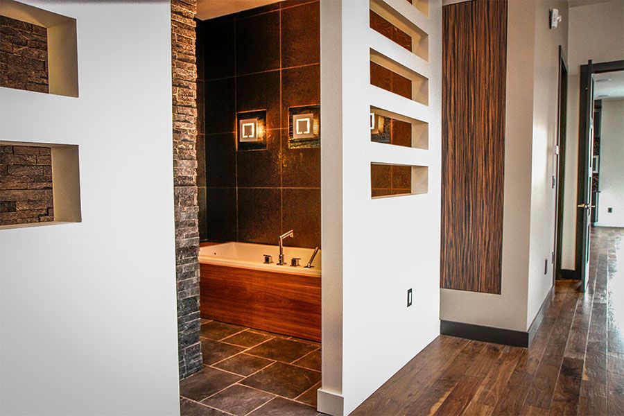 A bathroom with a bathtub and a wooden floor