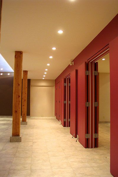 A long hallway with red walls and wooden pillars