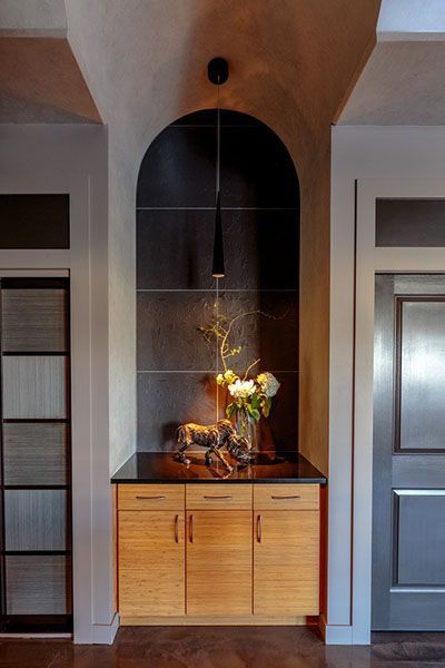A cabinet with a vase of flowers on top of it in a room.