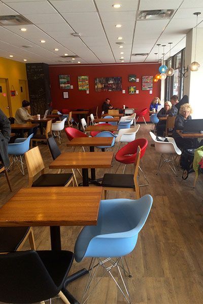 A restaurant with tables and chairs and people sitting at them