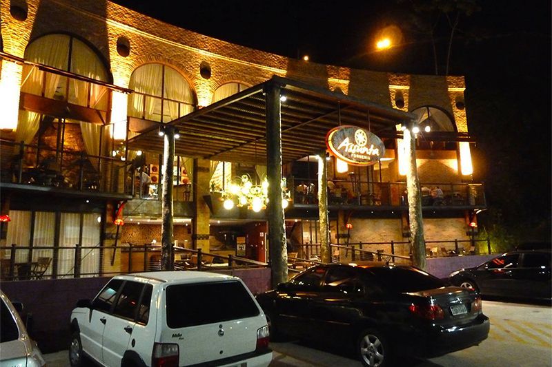 A white van is parked in front of a restaurant at night