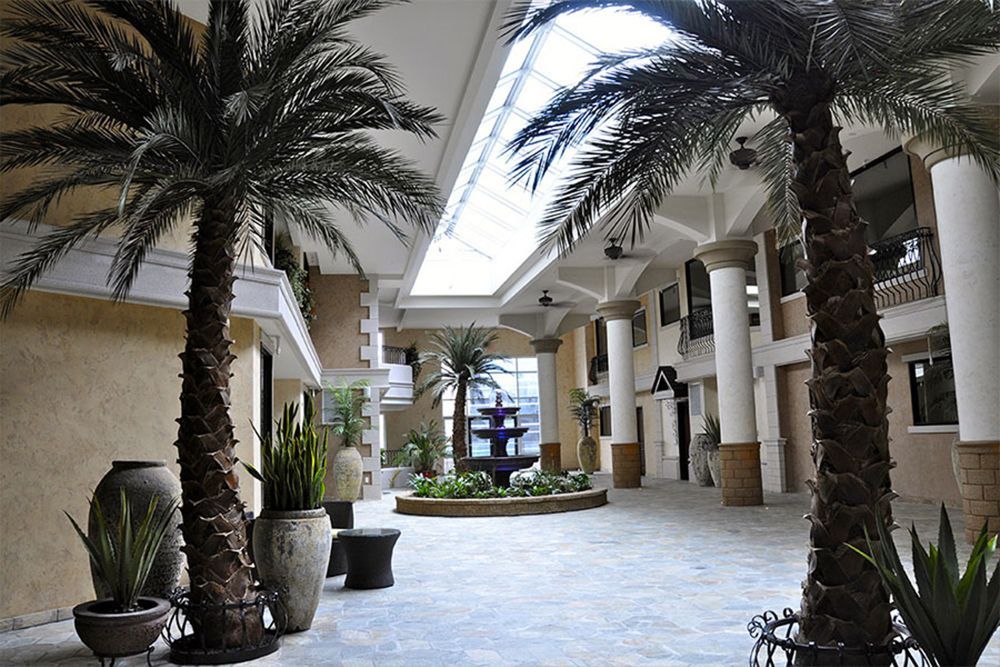 A building with palm trees and a fountain in the middle