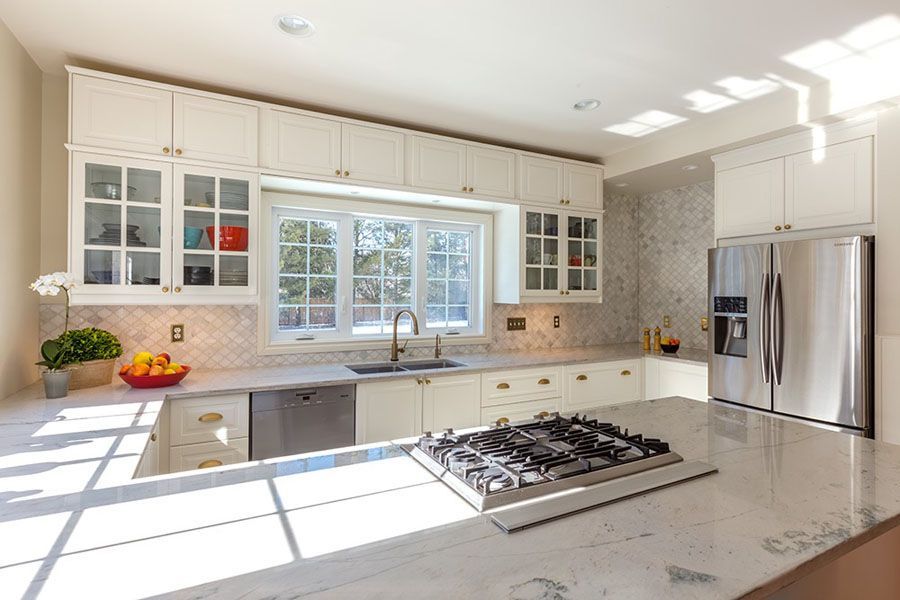 A kitchen with white cabinets and stainless steel appliances