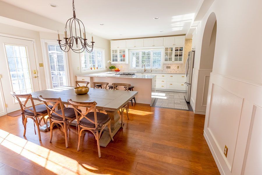 A kitchen with a table and chairs and a chandelier.