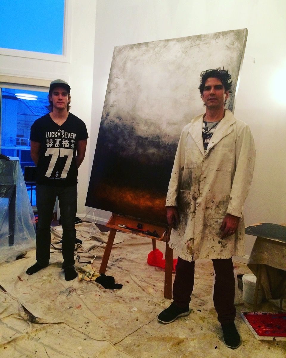 A man in a 77 shirt is standing next to a man in a white coat