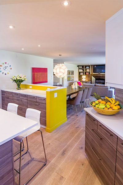 A kitchen with a yellow wall and a bowl of fruit on the counter.
