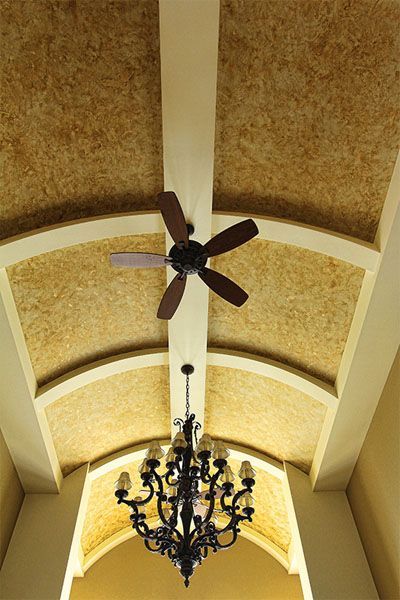 A ceiling fan is hanging from the ceiling above a chandelier.