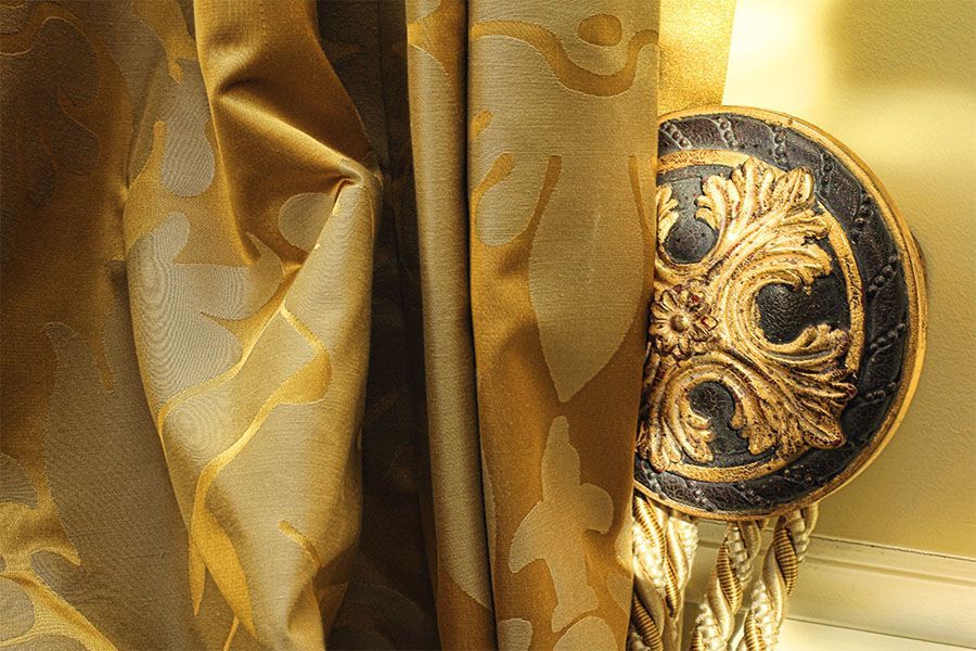 A close up of a gold curtain with a black and gold trim