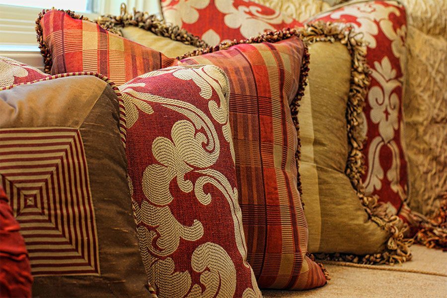 A bunch of colorful pillows are sitting on a couch