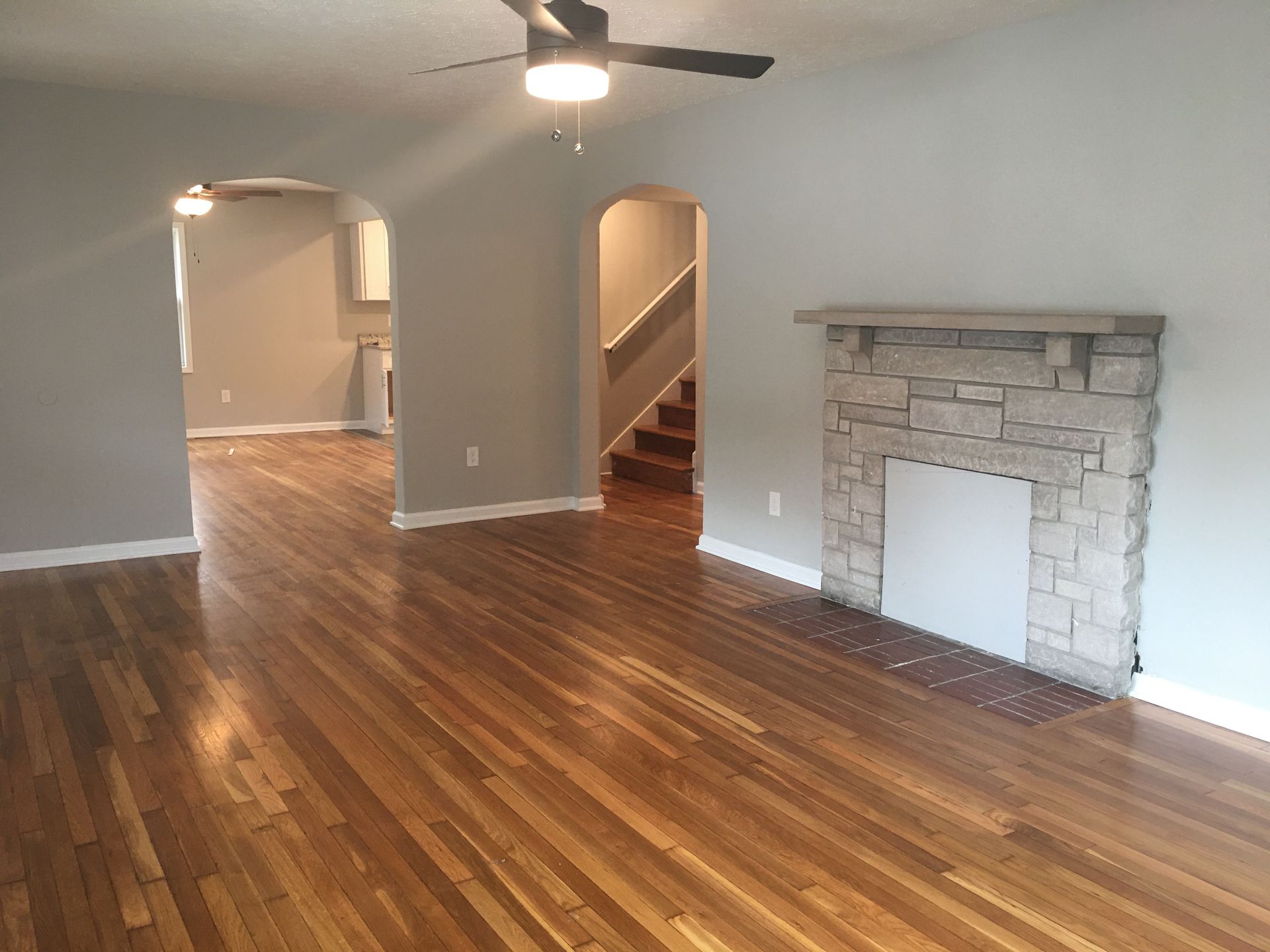 Photo of a living room with a flight of stairs int he background