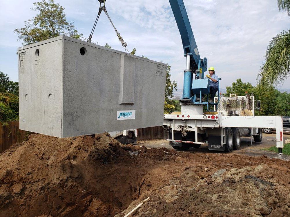 A large concrete box is being lifted by a crane