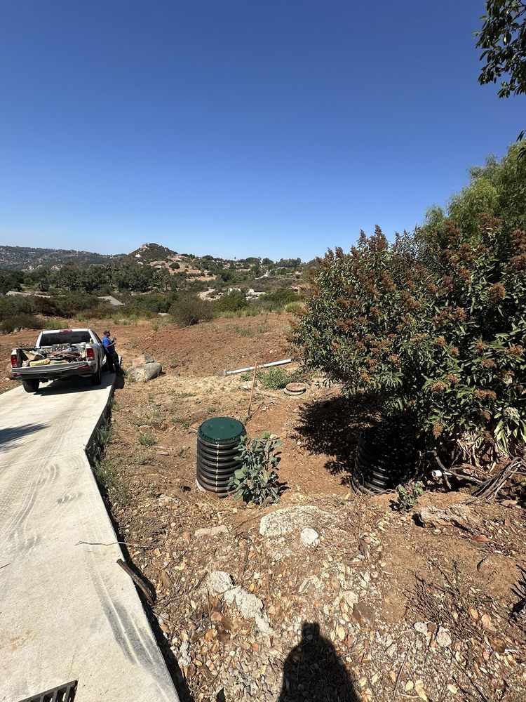 A truck is parked on the side of a dirt road.