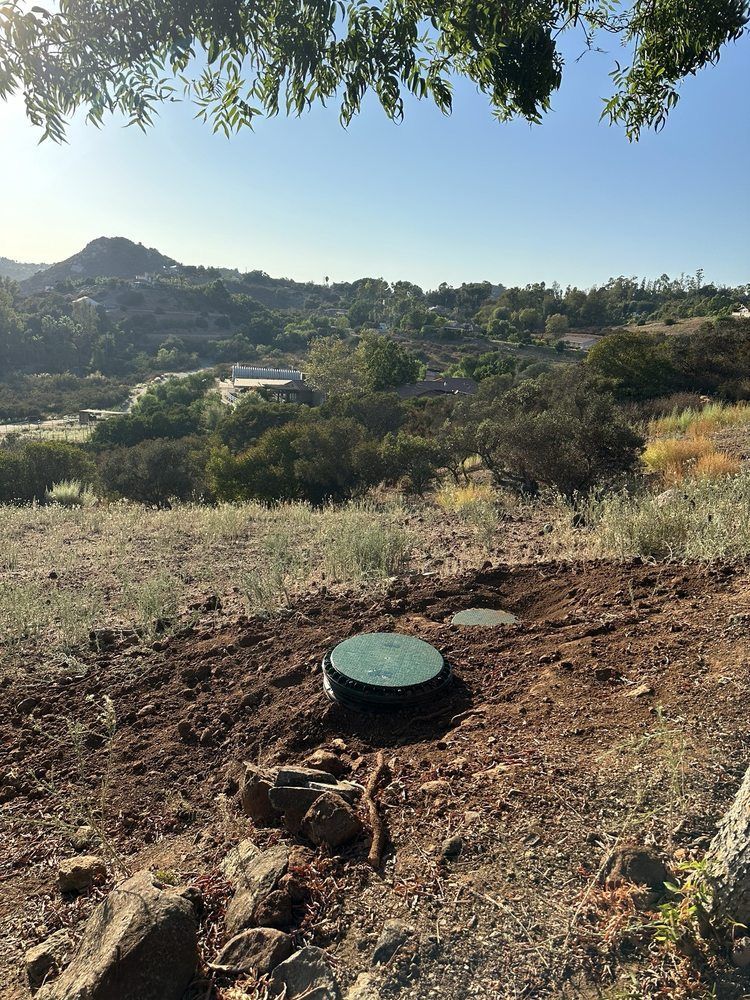 A septic tank is sitting in the middle of a dirt field.
