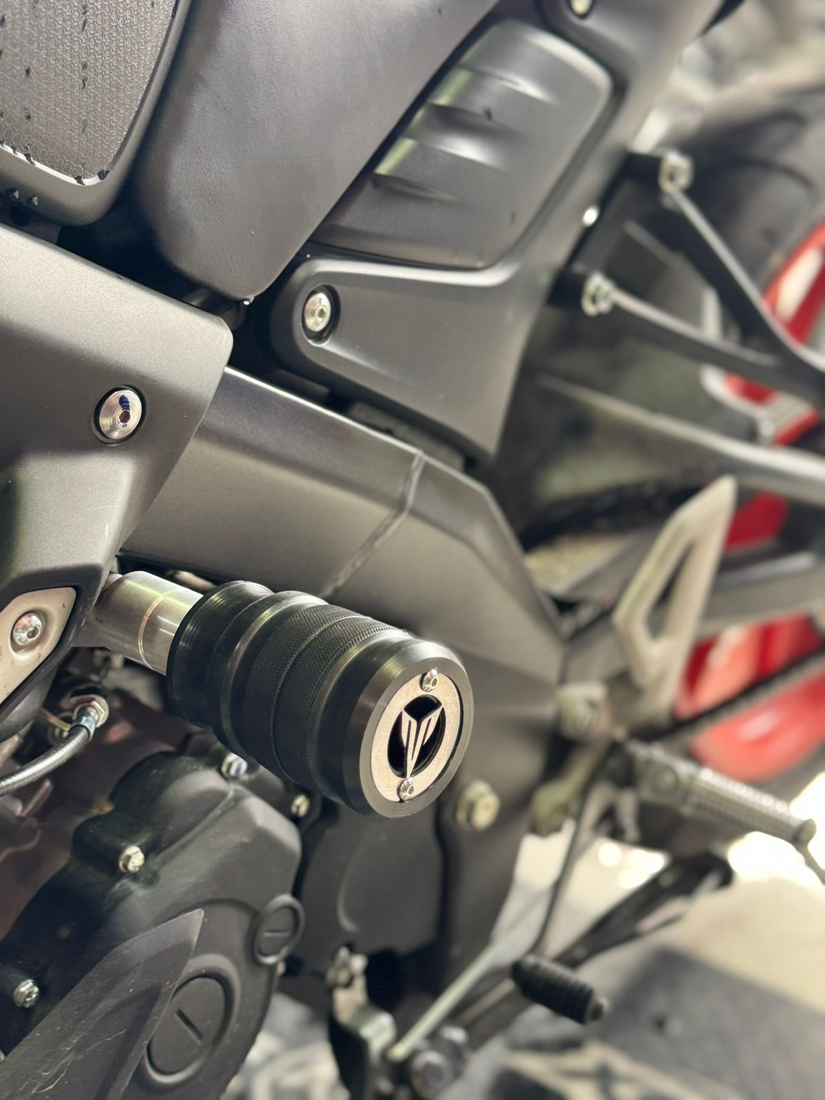 Motocicleta Yamaha negra y plateada con protectores anticolisión; vista de cerca.