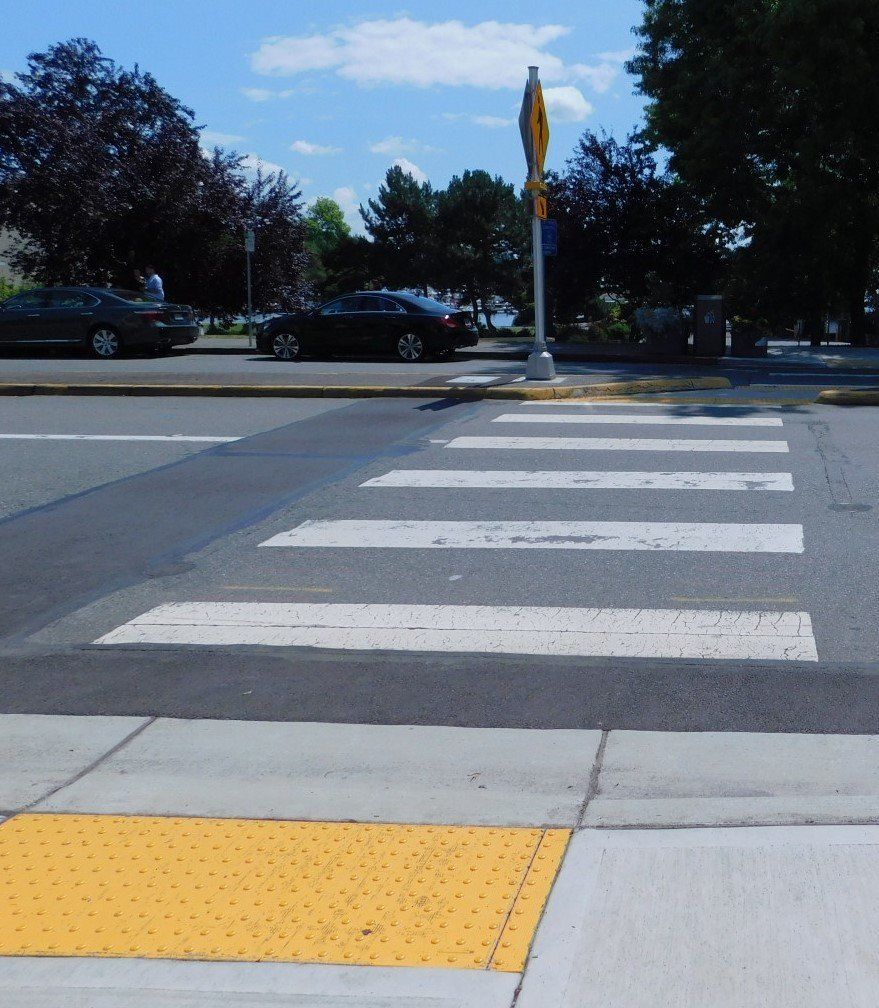 a crosswalk with a yellow area on the sidewalk