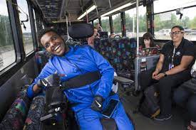 a man in a blue suit is sitting in a wheelchair on a bus .