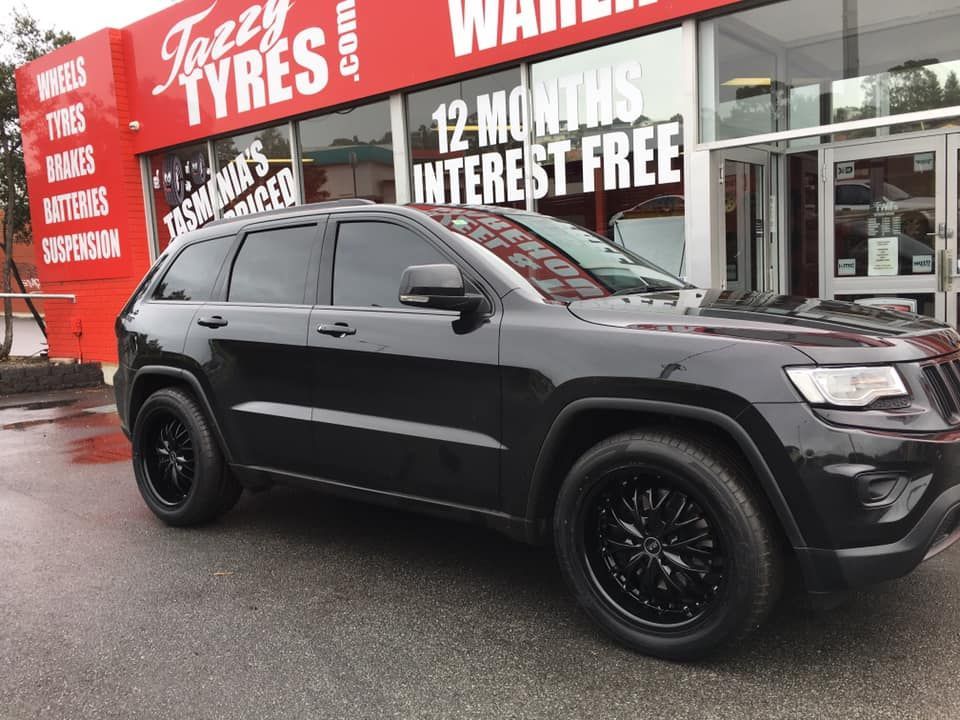White campervan with red stripe parked in front of a building.