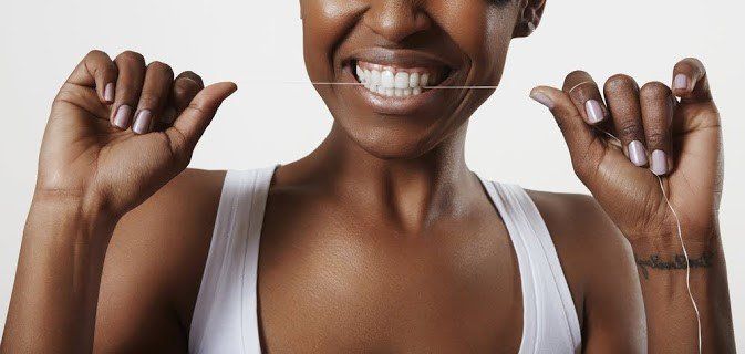 Woman Cleaning Teeth Using Flossing — Naples, FL — Bradley Piotrowski, DDS, MSD, LLC