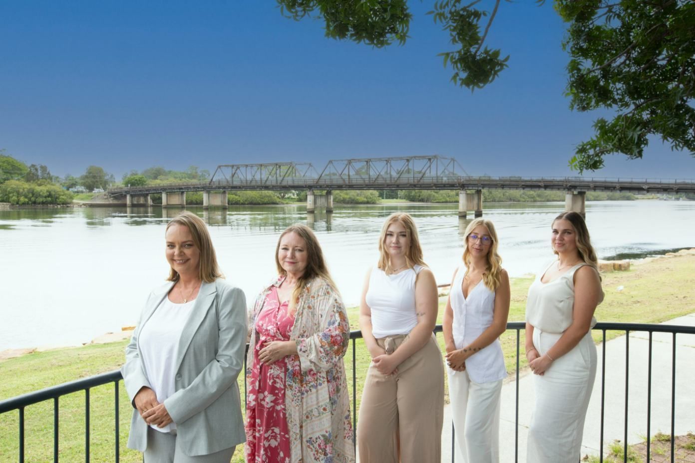 Five Women Stand on a Deck Overlooking a River and Bridge — Daly Legal In Macksville, NSW