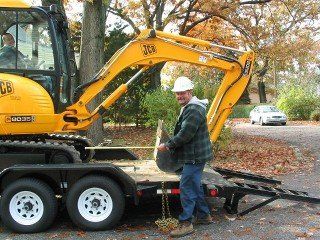 Backhoe Digging a Hole - Sewer Line Installations