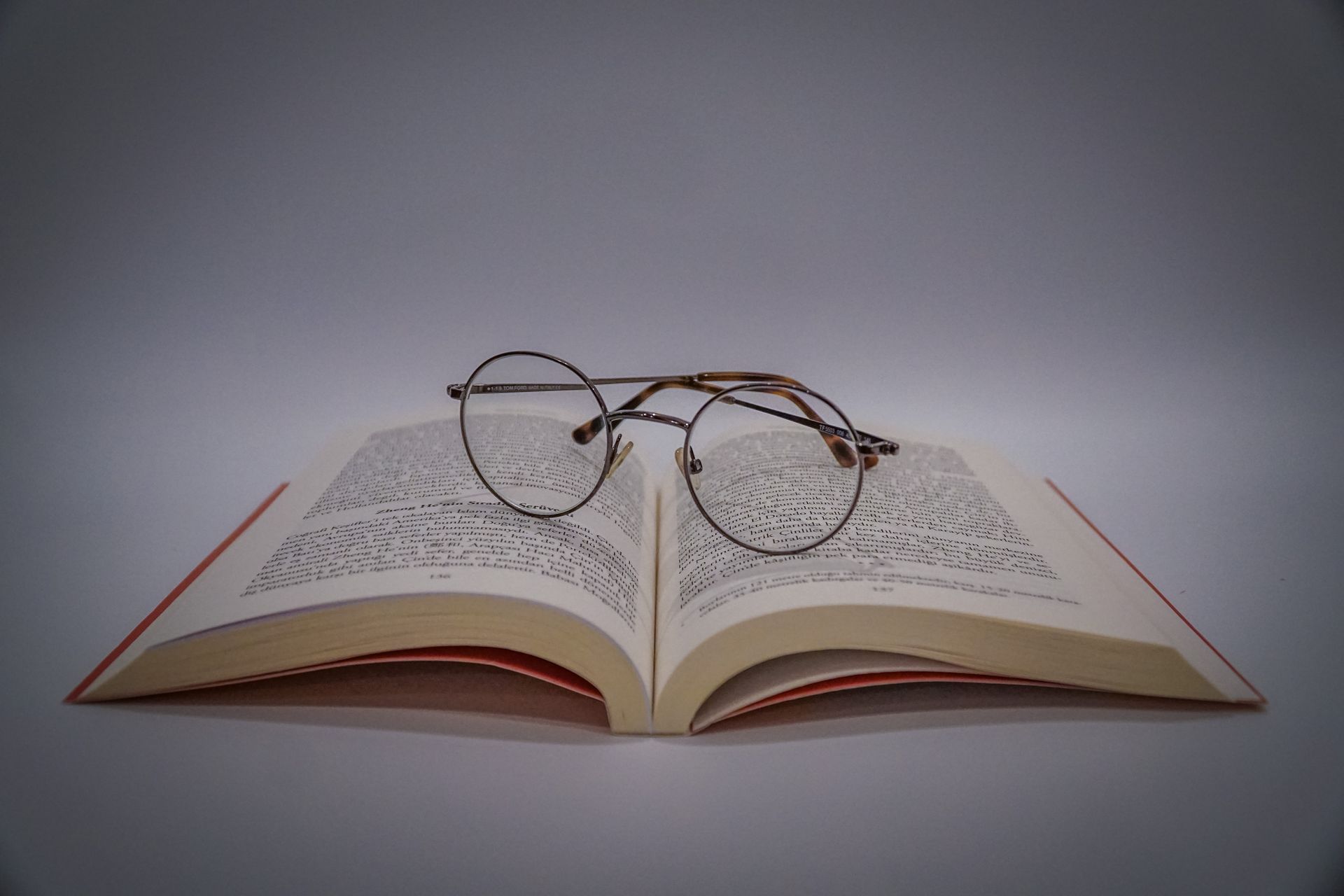 a pair of glasses is sitting on top of an open book .
