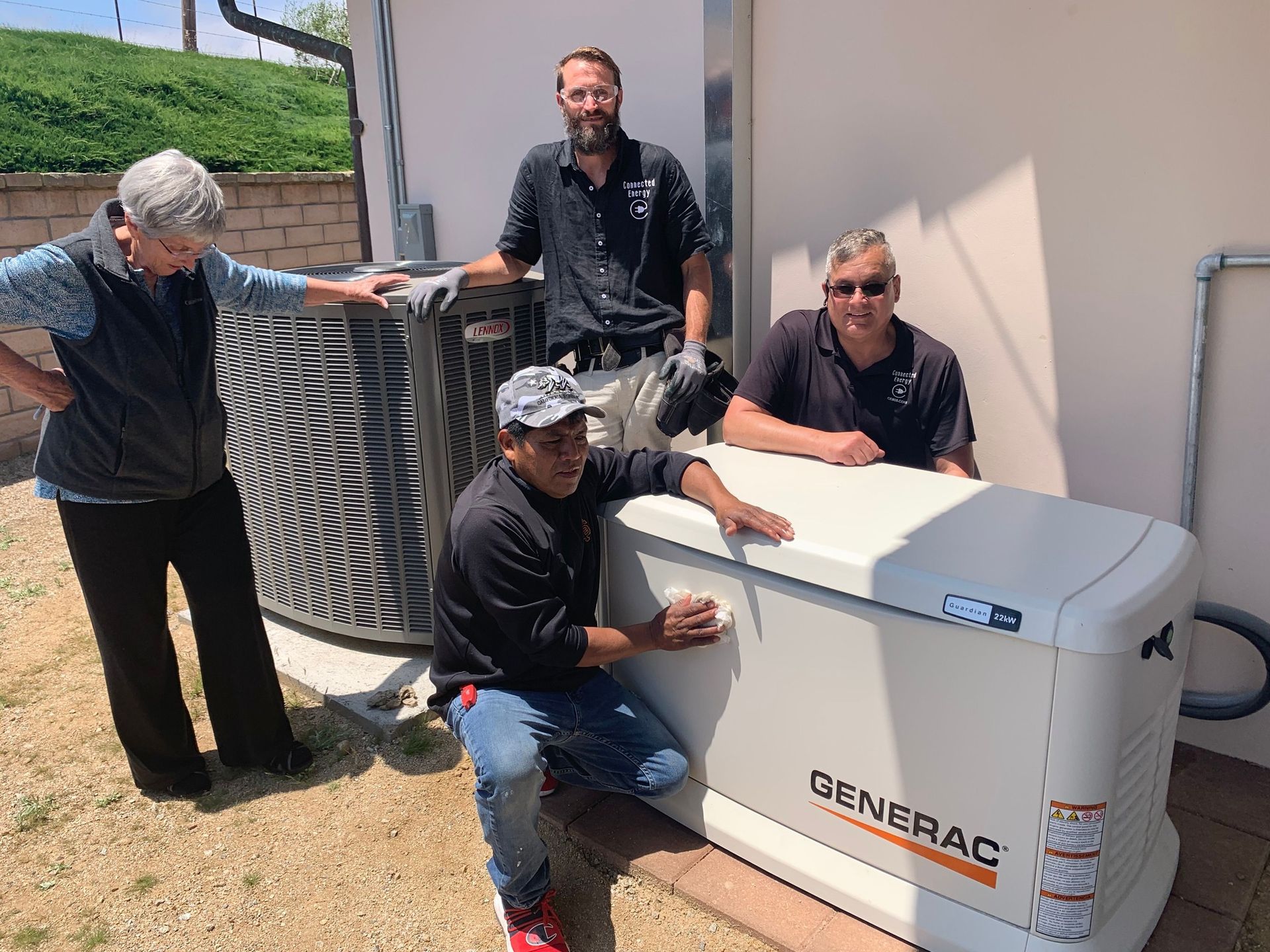 A group of people are standing around a generator.