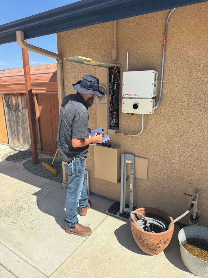 A man is working on a solar panel on the side of a house.