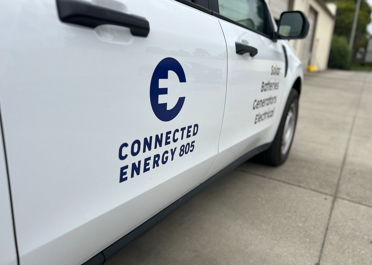 A man is sitting at a table holding a cell phone.