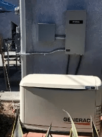 A generator is sitting on the side of a building.