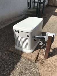 A white generator is sitting on top of a wooden table.
