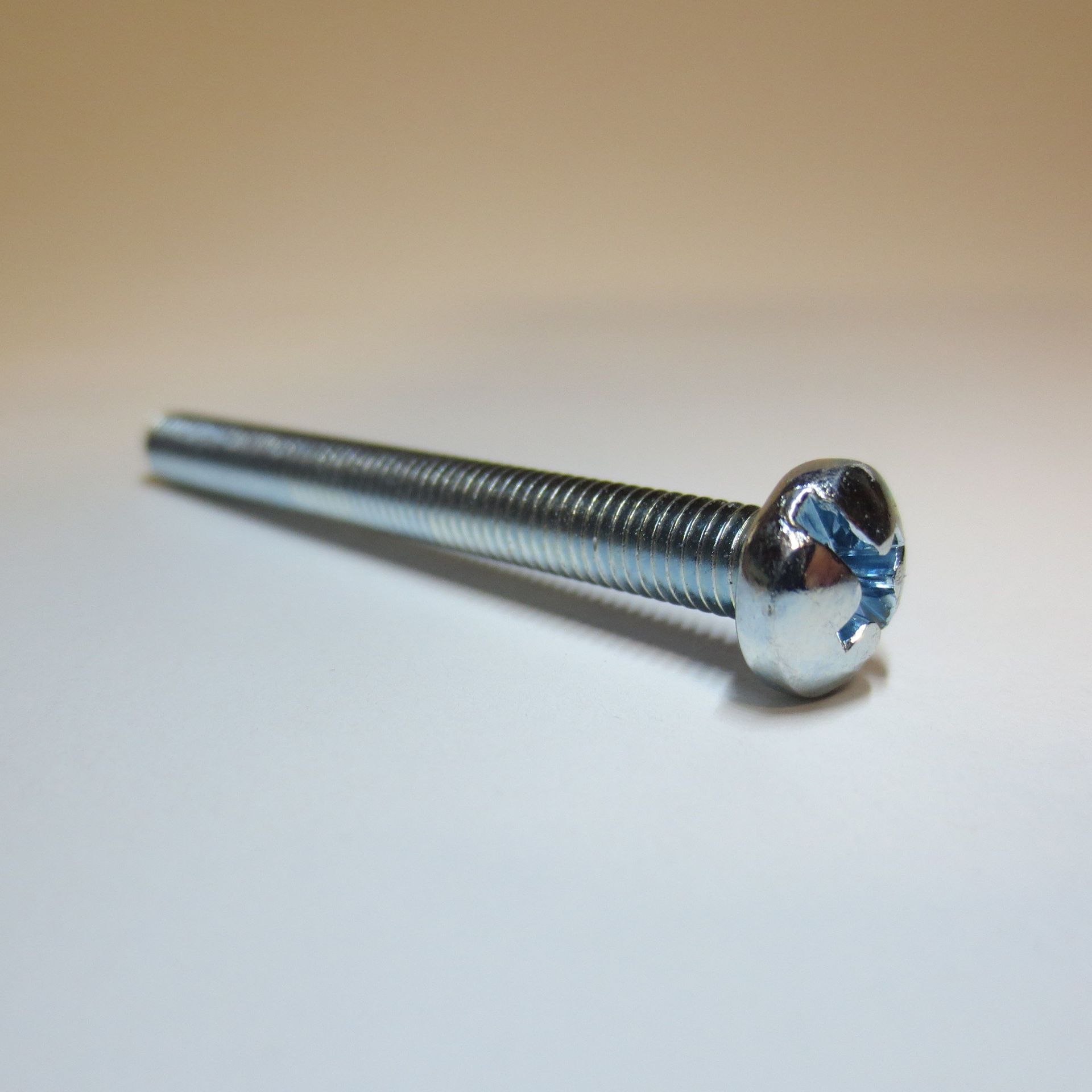 Eine Nahaufnahme einer Schraube auf einer weißen Oberfläche