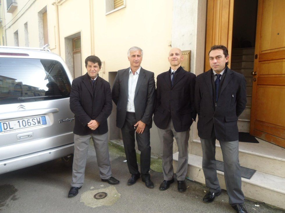 delle persone di fianco a un carro funebre